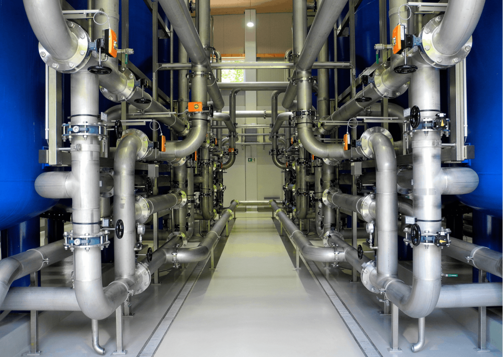 Een lange gang met leidingen en kleppen die de ruimte vullen.
